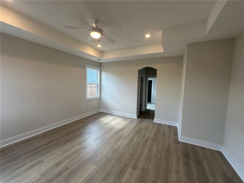 This primary bedroom features elegant tray ceiling