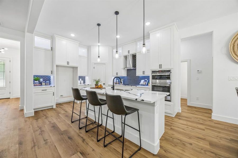 Modern kitchen featuring a central island with countertop seating and pendant lighting.