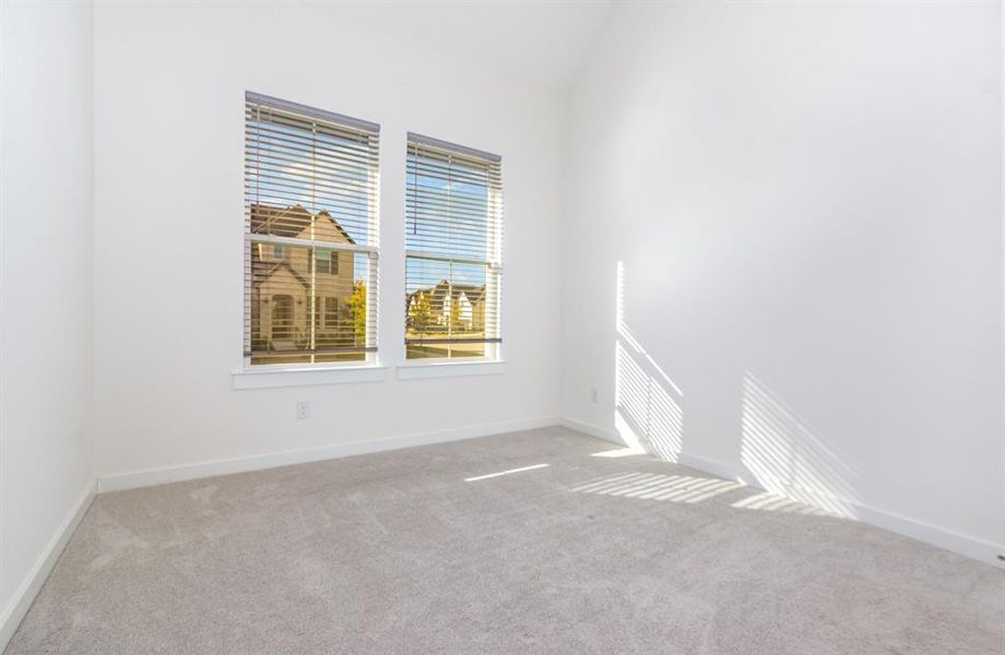 Unfurnished room with carpet flooring and vaulted ceiling Unfurnished room with carpet flooring and vaulted ceiling