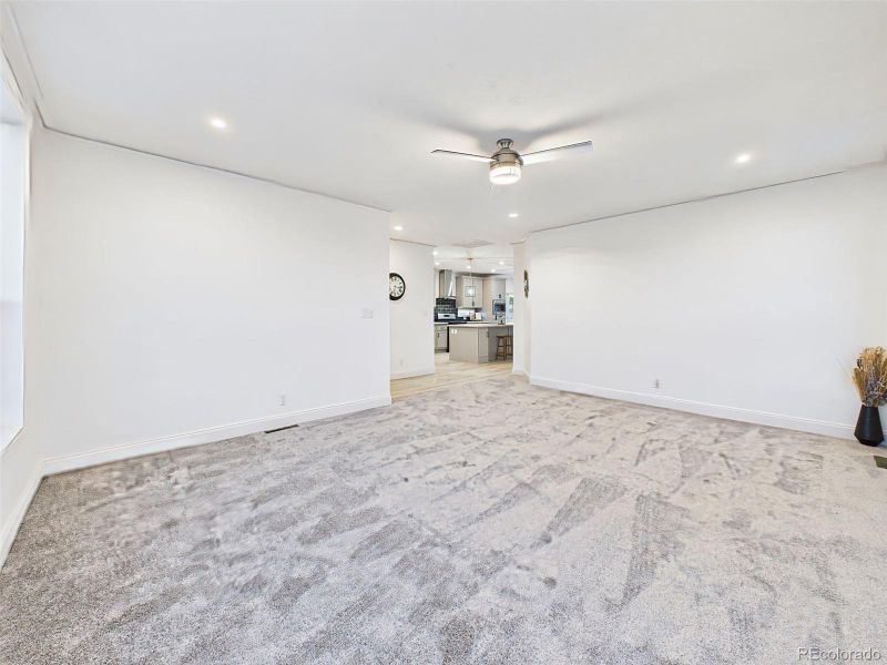 Un-staged version of the main living area, highlighting the fresh paint, new carpet, and seamless flow into the kitchen. Un-staged version of the main living area, highlighting the fresh paint, new carpet, and seamless flow into the kitchen.