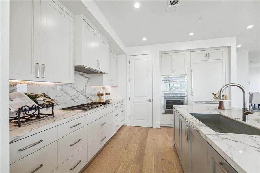 The kitchen has beautiful countertops with matching backsplash, walk-in pantry and Thermador appliances throughout.