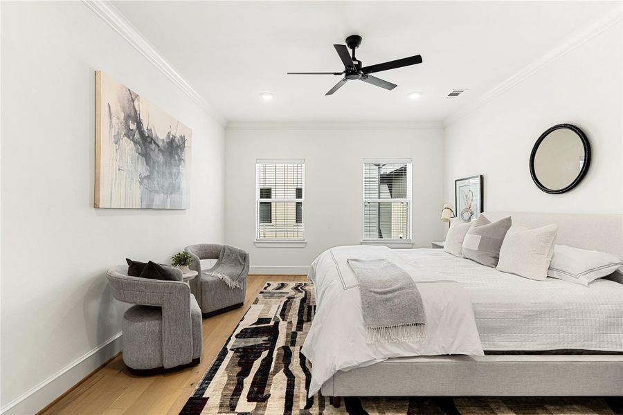 Spacious third-floor primary bedroom featuring a comfortable sitting area and a king-sized bed setup, offering a perfect blend of relaxation and modern comfort.