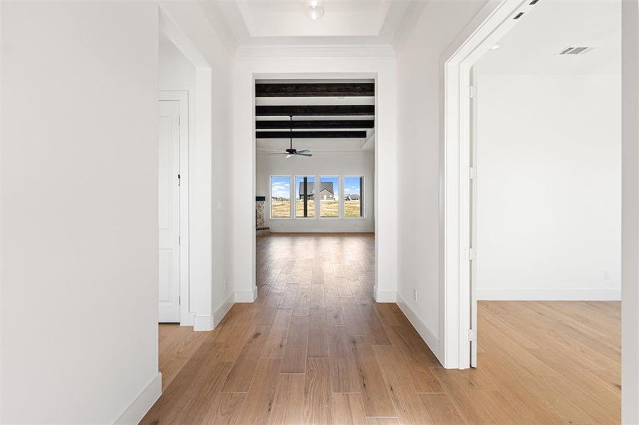 Corridor with light wood-type flooring and beam ceiling