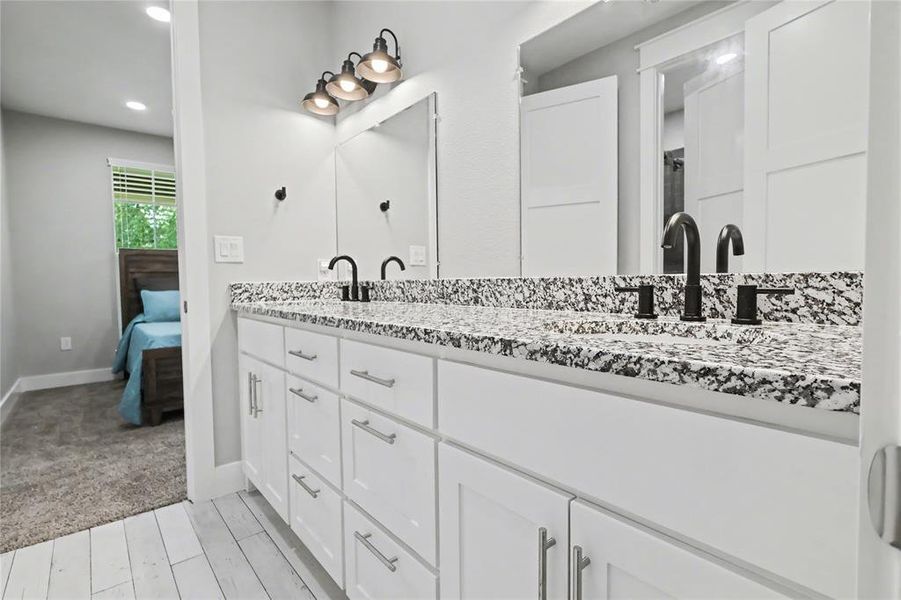 Dual vanity with white cabinetry and granite-patterned countertops