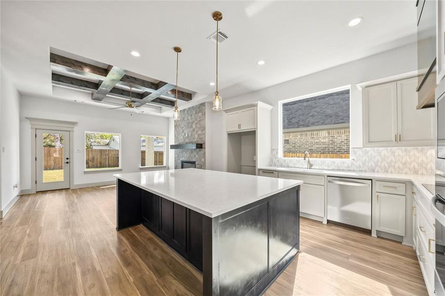 Kitchen featuring coffered ceiling, a ceiling fan, beam ceiling, light wood-type flooring, and white cabinetry
