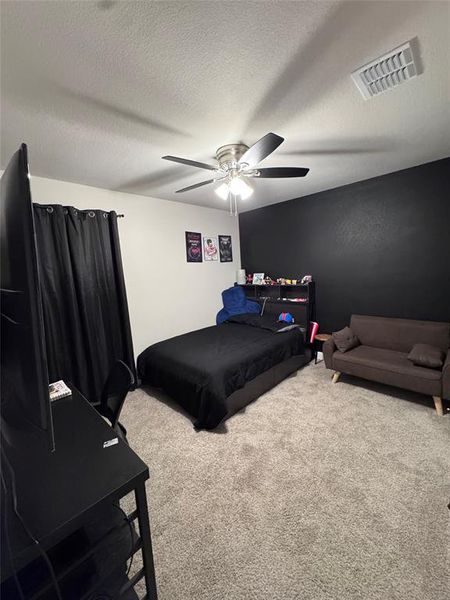 Bedroom 2 featuring a black accent wall, and a ceiling fan with integrated lighting