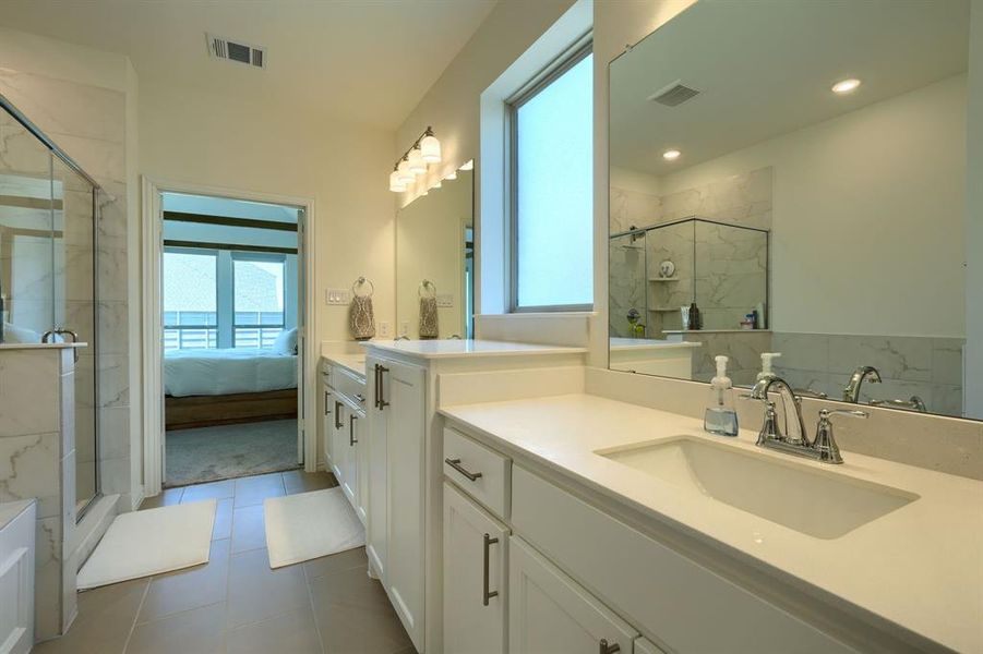 Bathroom with vanity, tile floors, and a shower with door