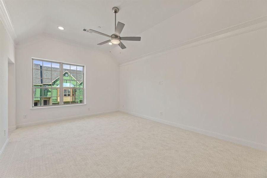 Spare room with lofted ceiling, light colored carpet, and crown molding