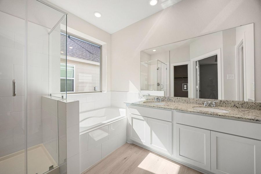 Step into the bright and luxurious primary bathroom sanctuary, designed as a tranquil extension of the main suite. This well-appointed space features an expansive dual vanity with crisp white shaker-style cabinetry, a granite countertop, and a large, frameless mirror that brightens the entire room. Step into the bright and luxurious primary bathroom sanctuary, designed as a tranquil extension of the main suite. This well-appointed space features an expansive dual vanity with crisp white shaker-style cabinetry, a granite countertop, and a large, frameless mirror that brightens the entire room.