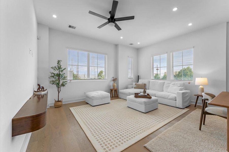 The second floor boasts a spacious open-concept living, dining, and kitchen area filled with natural light from abundant windows, featuring sleek modern finishes and warm engineered hardwood floors that create the perfect blend of style and comfort for everyday living and entertaining.