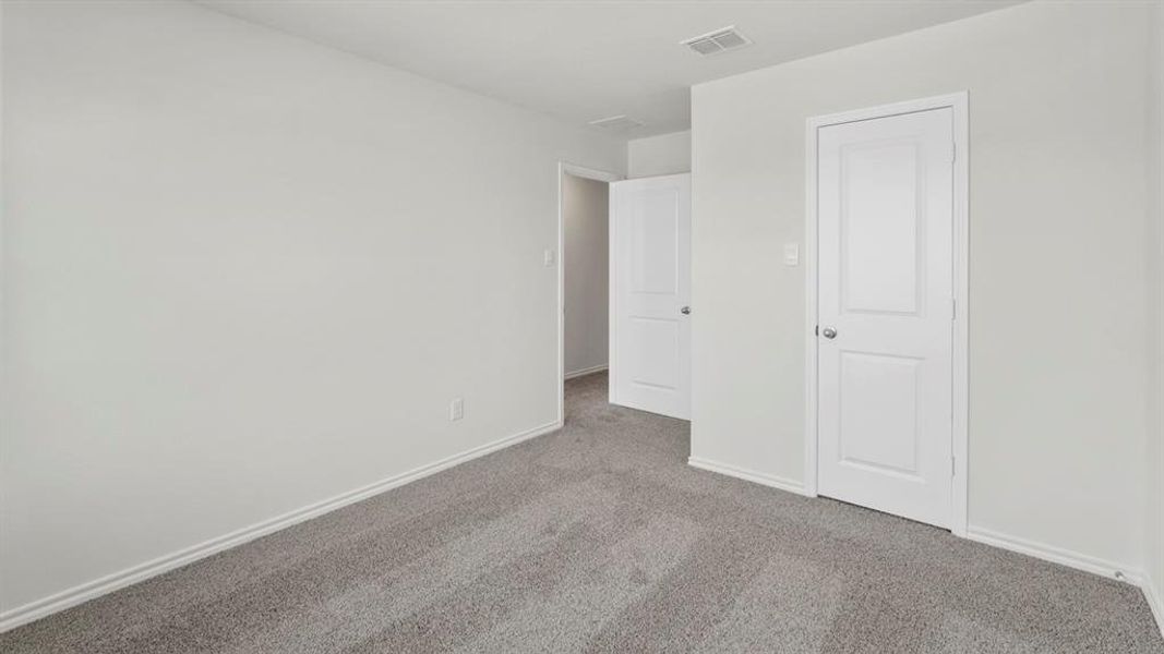 Room featuring light gray carpet, white walls, and white doors with silver hardware