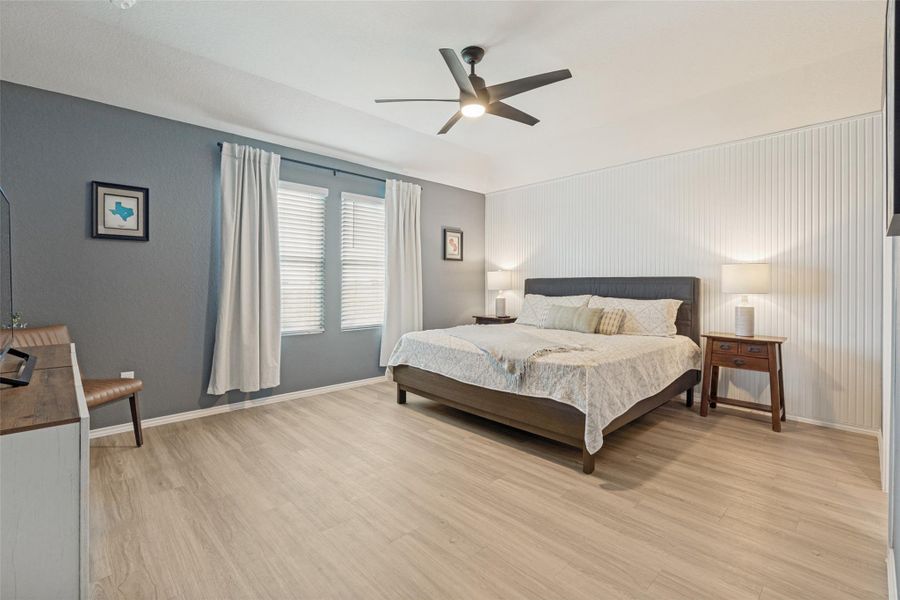 Well-lit sleeping quarters with a ceiling fan overhead and neutral flooring throughout.