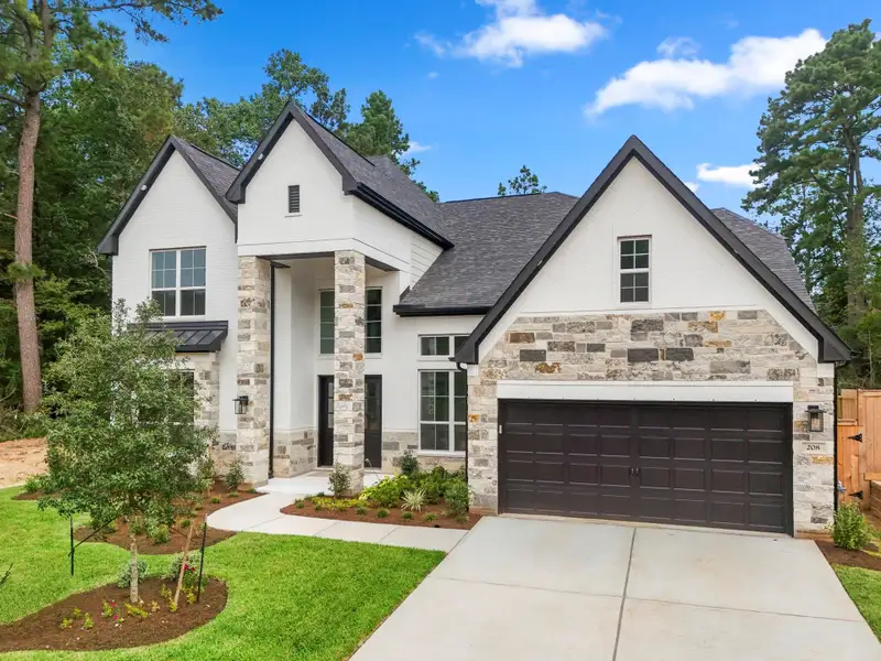 Front exterior of a new home in The Woodlands Hills, Willis, TX, highlighting curb appeal (Image 8). Front exterior of a new home in The Woodlands Hills, Willis, TX, highlighting curb appeal (Image 8).