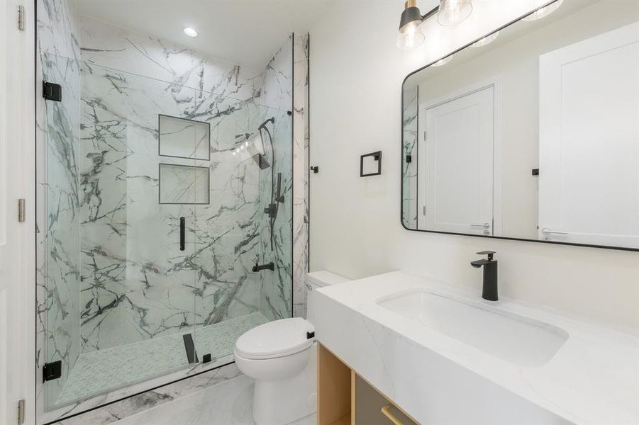 Bathroom featuring vanity, marble look tile flooring, a marble finish shower, and recessed lighting Bathroom featuring vanity, marble look tile flooring, a marble finish shower, and recessed lighting