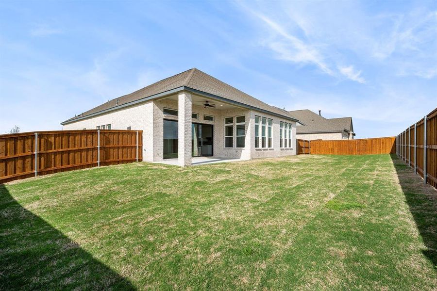 Rear view of house with a patio area, a lawn, and ceiling fan