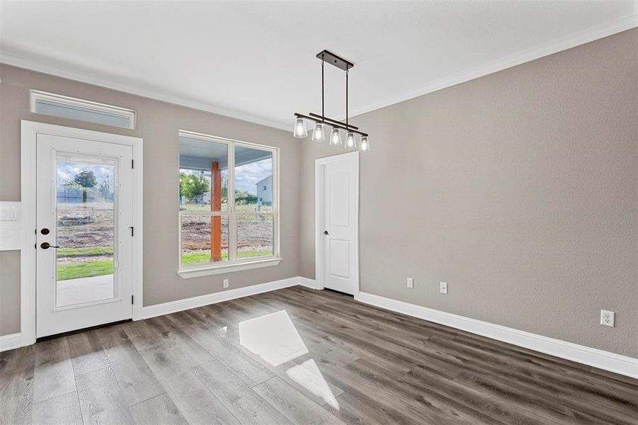 Unfurnished dining area featuring hardwood / wood-style flooring and ornamental molding