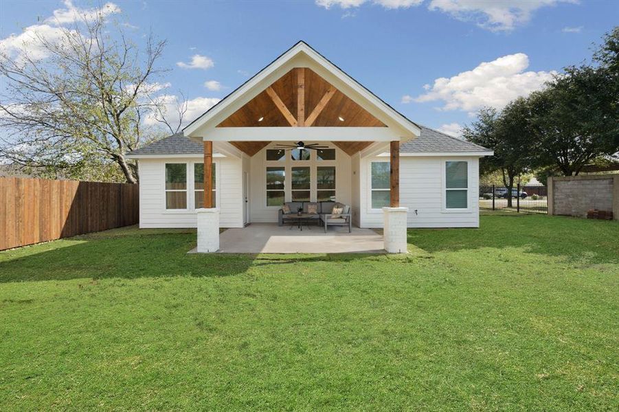 Back of property with ceiling fan, roof with shingles, and a patio Back of property with ceiling fan, roof with shingles, and a patio