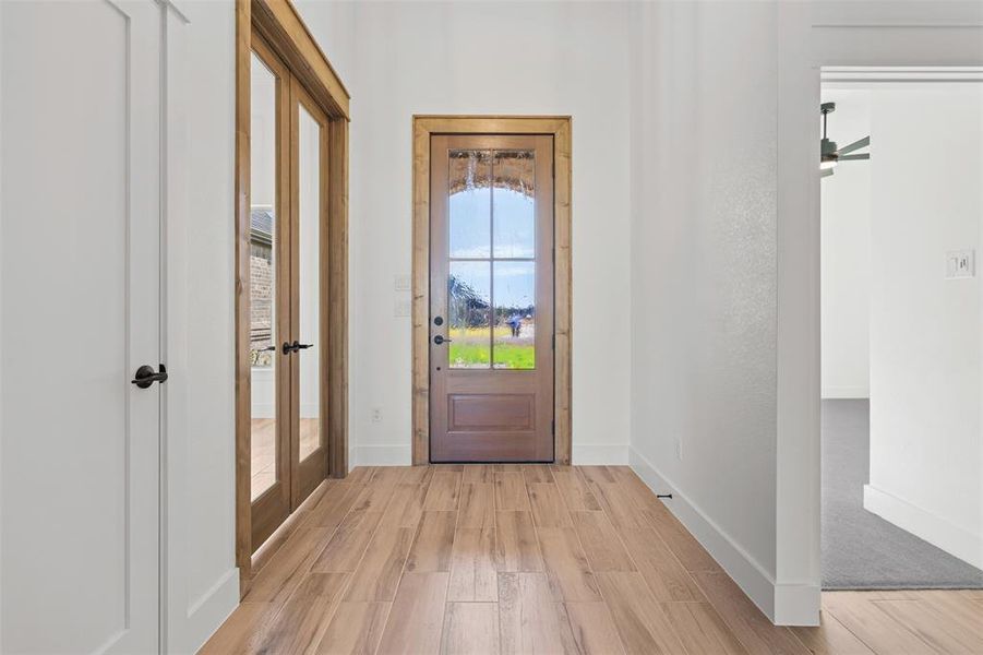Doorway to outside with wood finished floors and a ceiling fan