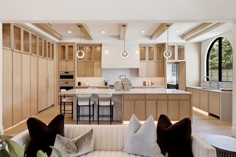 The chef’s kitchen is a masterpiece, featuring a Wolf steam oven, a built-in Miele coffee maker, Bianco Superiore Quartzite countertops, a 48-inch range, and SubZero refrigerator and freezer units