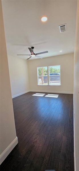 Unfurnished room with dark wood finished floors, a ceiling fan, and recessed lighting Unfurnished room with dark wood finished floors, a ceiling fan, and recessed lighting