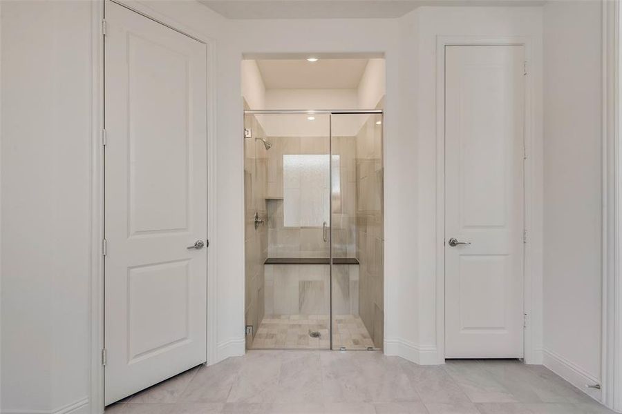 Bathroom with tile patterned floors and a shower with shower door