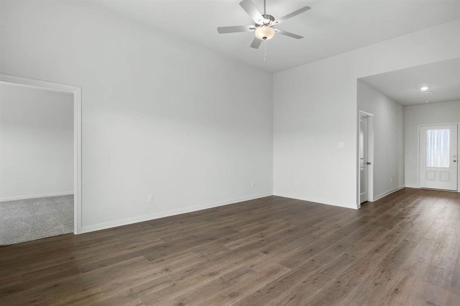Spare room with dark wood-type flooring and ceiling fan