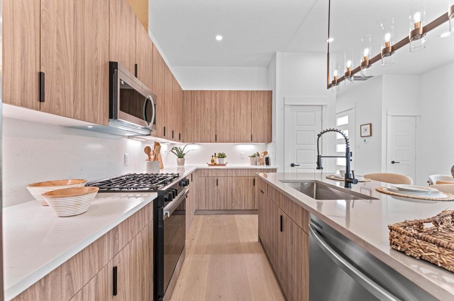 This stylish kitchen showcases plenty of sleek cabinetry, thoughtfully arranged to maximize storage and enhance the room’s modern aesthetic. Upper and lower cabinets feature clean lines and minimalist hardware, blending seamlessly with the space’s contemporary design.