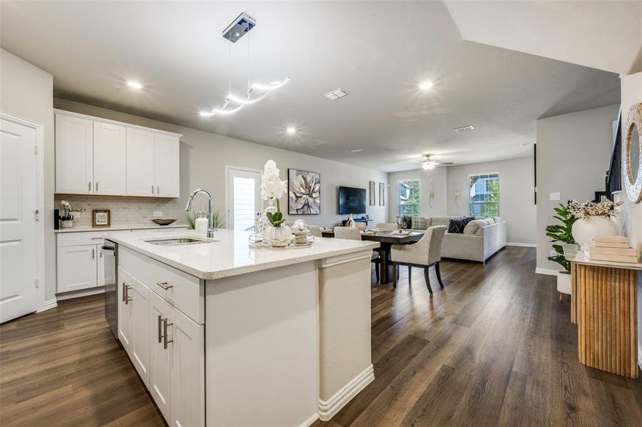 Kitchen featuring white cabinetry, tasteful backsplash, hanging light fixtures, open floor plan, and recessed lighting Kitchen featuring white cabinetry, tasteful backsplash, hanging light fixtures, open floor plan, and recessed lighting