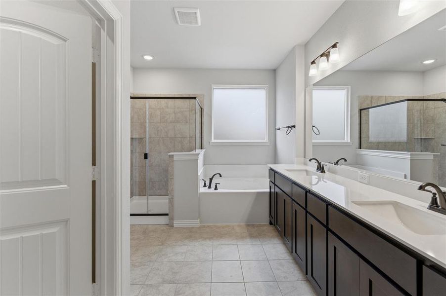 Bathroom with double vanity, a bath, a stall shower, and light tile patterned floors
