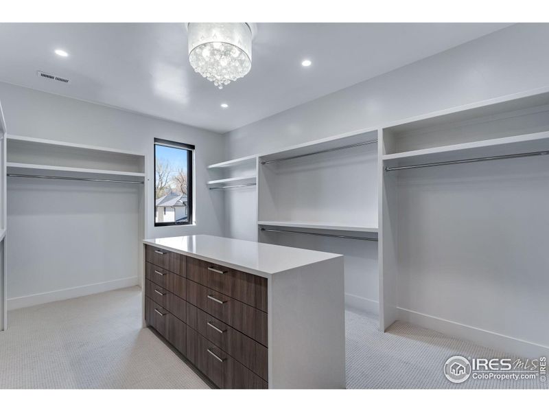 Large primary closet with island and drawers