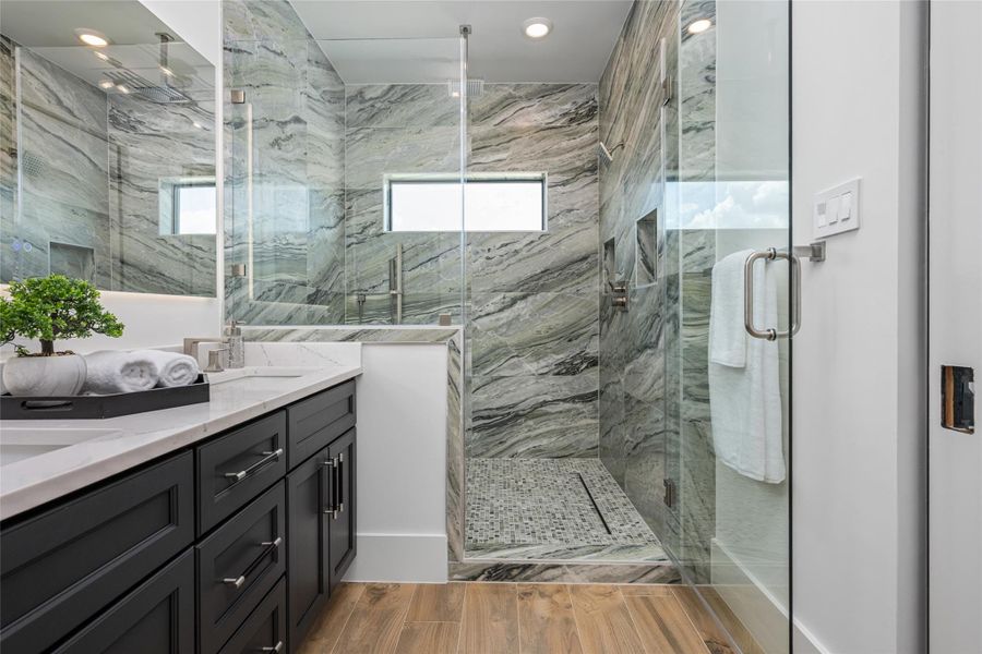 The shower suite boasts three heads—rainfall, wall-mounted, and handheld—surrounded by porcelain tile to the ceiling and framed by a bright window The shower suite boasts three heads—rainfall, wall-mounted, and handheld—surrounded by porcelain tile to the ceiling and framed by a bright window