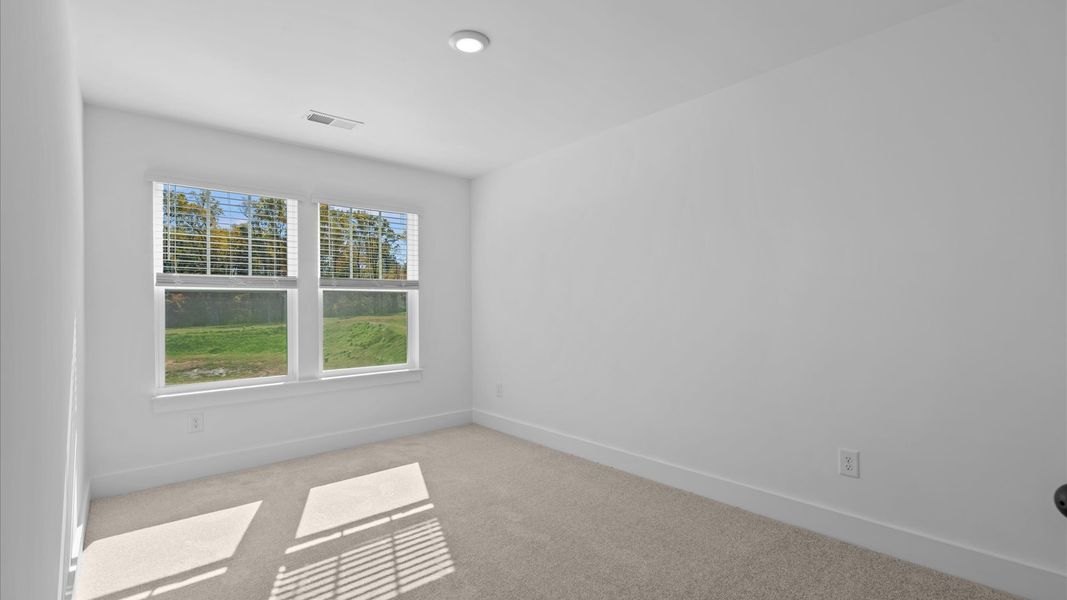 Inviting bedroom with tasteful finishes and large windows that create a fresh, open ambiance