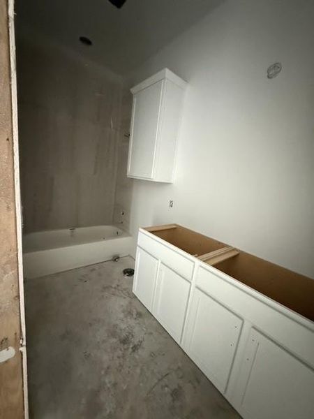 A new construction bathroom awaits customization with a bathtub, ready for finishing touches.