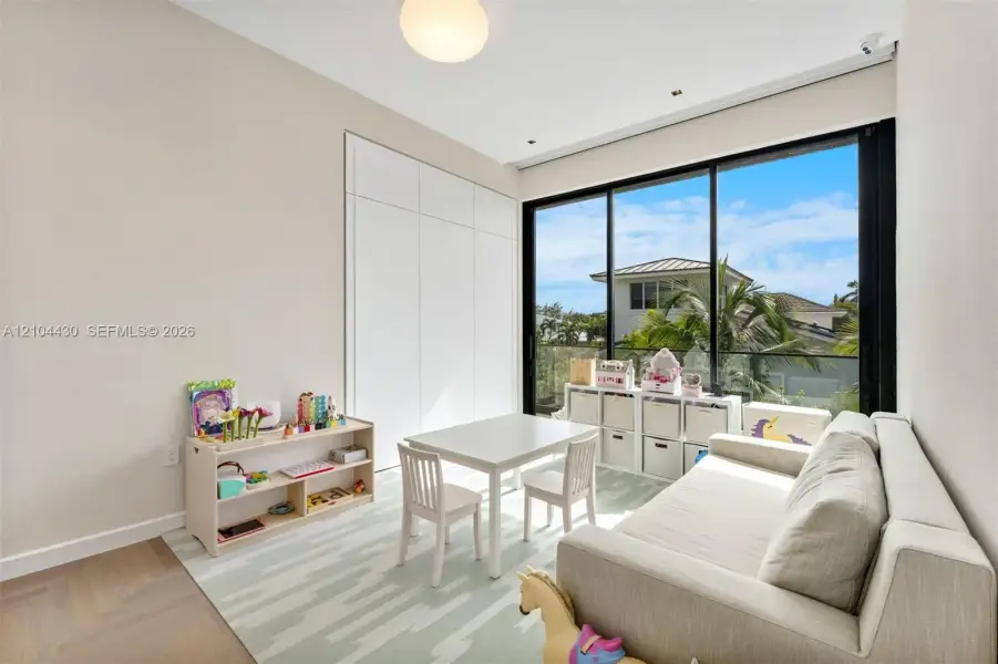 Floor-to-ceiling glass sliding doors, wood-finish herringbone flooring, built-in floor-to-ceiling cabinetry, recessed lighting, and a globe pendant fixture