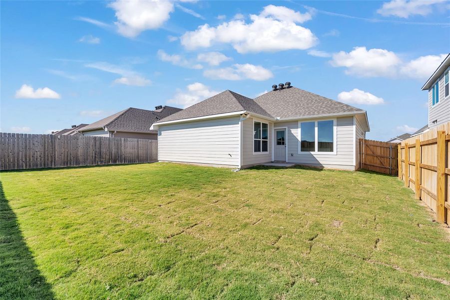 Rear view of property with a fenced backyard and roof with shingles