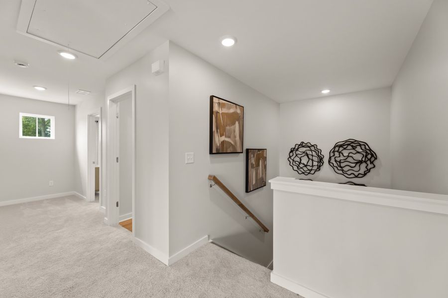 A room with a white wall and a white staircase.
