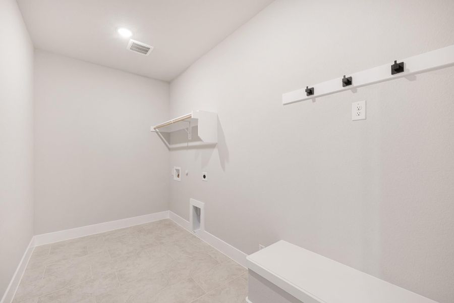Laundry or mudroom with white walls, wall-mounted hooks, a shelf, built-in bench, and tile floor Laundry or mudroom with white walls, wall-mounted hooks, a shelf, built-in bench, and tile floor