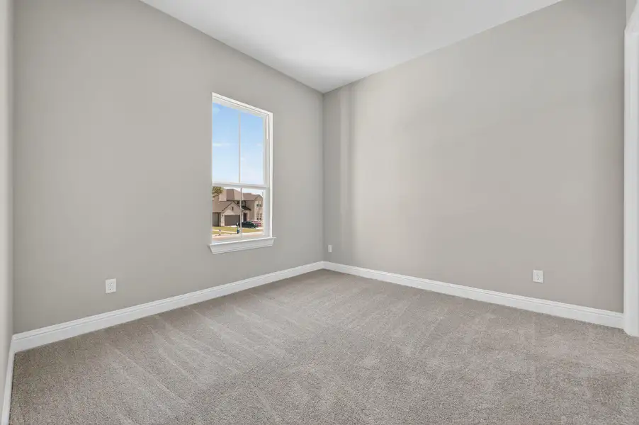 Empty room featuring light carpet and baseboards