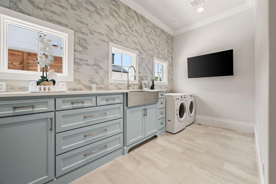 Laundry room featuring washing machine and dryer, ornamental molding, and cabinet space Laundry room featuring washing machine and dryer, ornamental molding, and cabinet space
