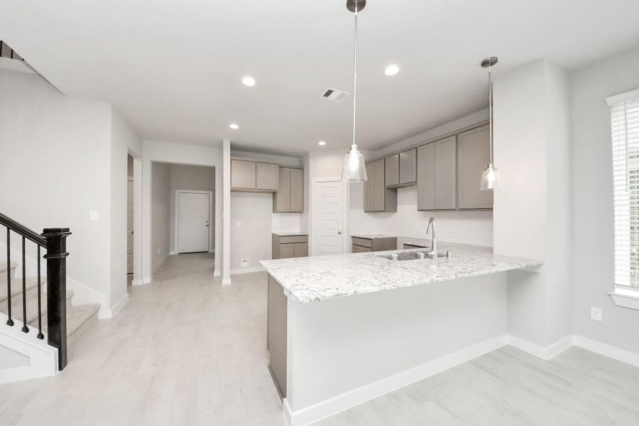 Discover another perspective of this stunning kitchen, generously appointed with an abundance of counter space! Sample photo of completed home with similar floor plan. Actual colors and selections may vary.