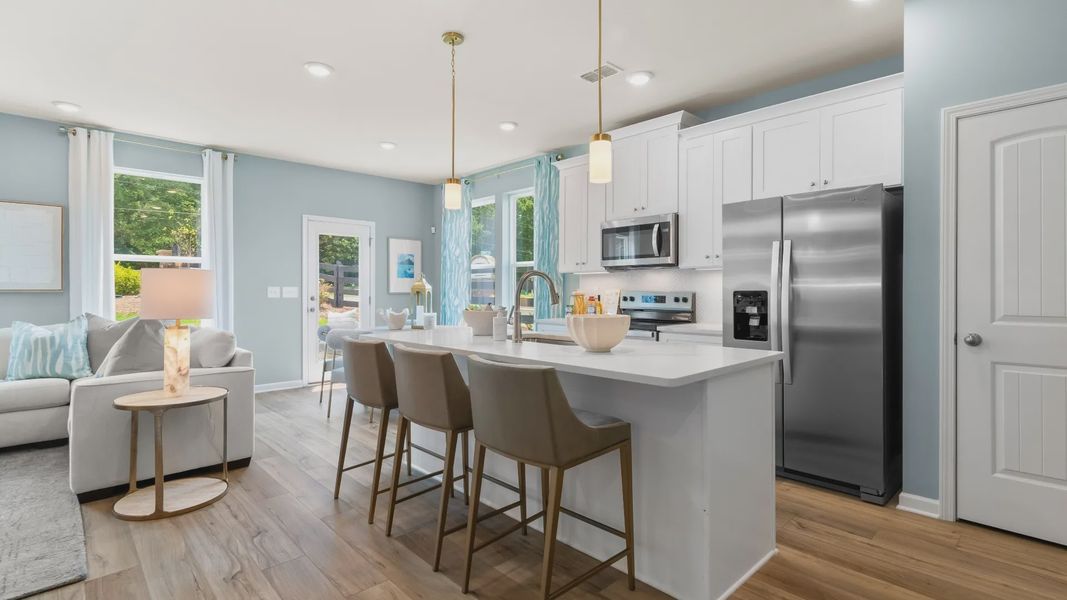 Modern kitchen in new construction townhome with large island, quartz countertops, and stainless appliances.