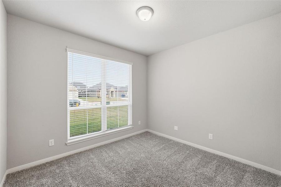 Carpeted spare room with baseboards