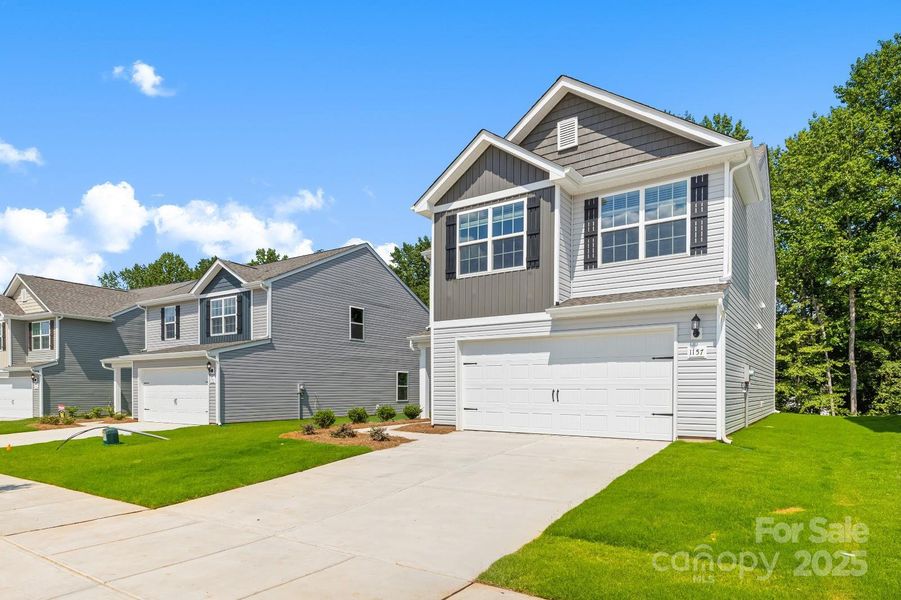 Front exterior of a new home in McKee Creek Village, Charlotte, NC, highlighting curb appeal (Image 2). Front exterior of a new home in McKee Creek Village, Charlotte, NC, highlighting curb appeal (Image 2).