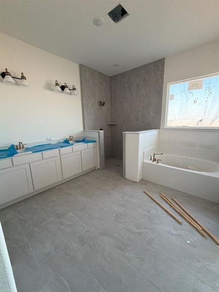 Bathroom with a garden tub, a walk in shower, and double vanity