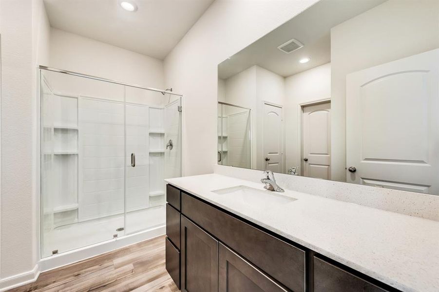 Bathroom featuring vanity, wood-type flooring, and an enclosed shower