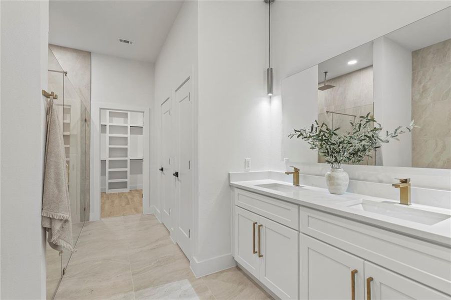 Full bath featuring a tile shower, double vanity, baseboards, a spacious closet, and recessed lighting Full bath featuring a tile shower, double vanity, baseboards, a spacious closet, and recessed lighting