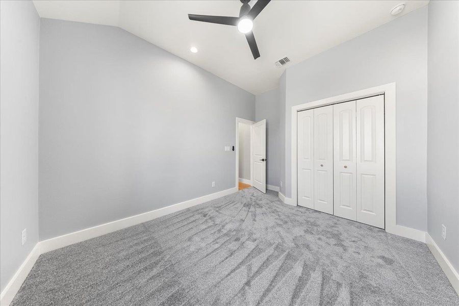 Unfurnished bedroom featuring vaulted ceiling, carpet floors, a ceiling fan, a closet, and recessed lighting Unfurnished bedroom featuring vaulted ceiling, carpet floors, a ceiling fan, a closet, and recessed lighting