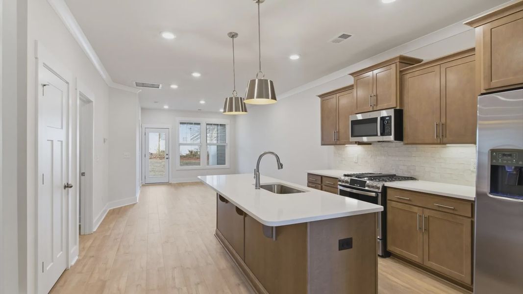 Tasteful kitchen with a streamlined island and modern finishes in a first-class DRB Homes design at Pelham Crossing