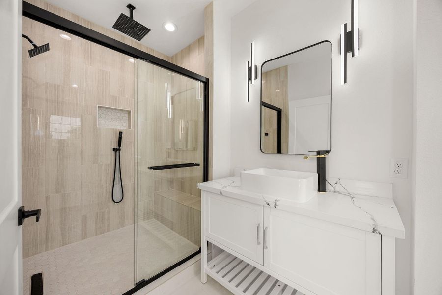 A spa-like primary bath featuring luxurious dual shower heads with multhiple sprayers, seperate dual vanities with mirrors, and beautiful LED ligting .