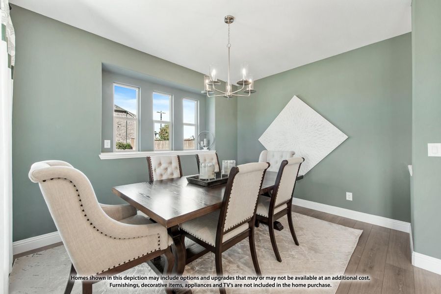 Dining room with dark wood table, upholstered chairs, chandelier, and sage green walls Dining room with dark wood table, upholstered chairs, chandelier, and sage green walls